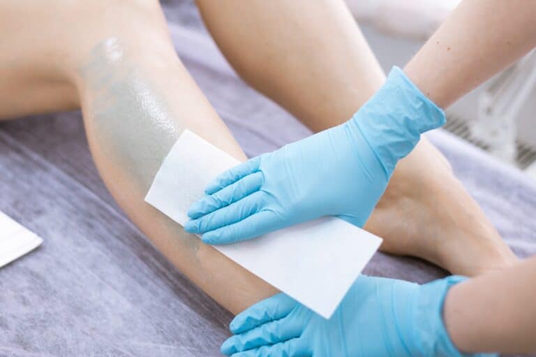 woman legs hair removal with wax in beauty salon